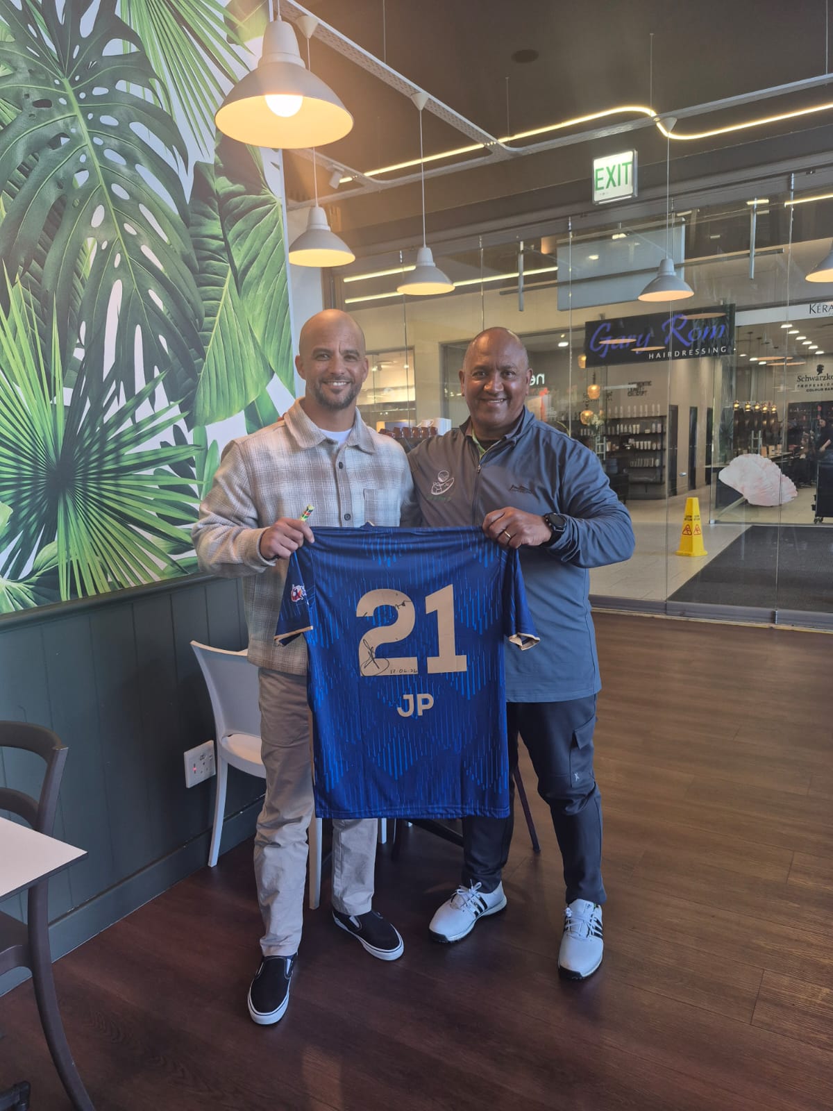 Brian Felix of Hillwood Golf Academy and JP Duminy holding a sports shirt with the number 21